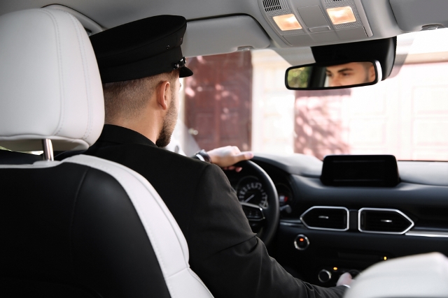 Young private chauffeur in the front seat driving a vehicle