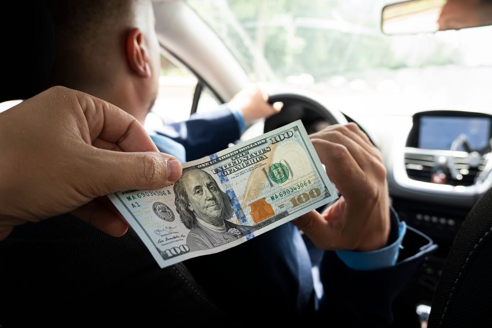 Private driver receiving tip from passenger